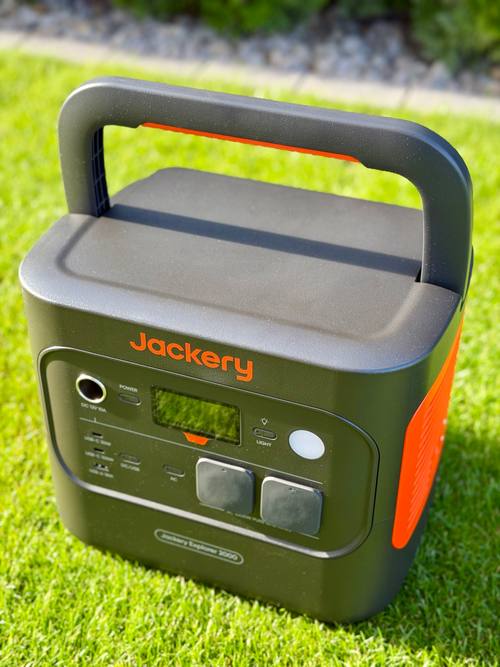 Jackery Explorer 2000 v2 schräg von oben auf dem Rasen, Tragegriff aufgestellt