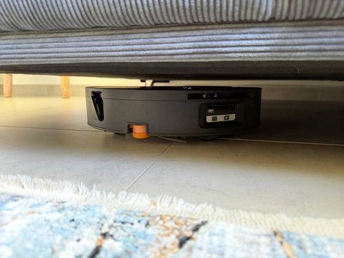 Roborock Saros 20 Flow unter einem grauen Sofa, zwischen Roboteroberseite und Sofaboden bleibt nur ein schmaler Spalt