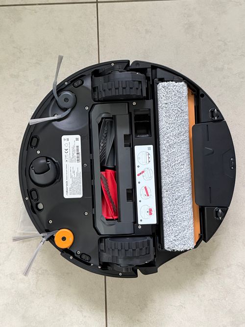 Unterseite des Roborock Saros 20 Flow mit grauer Wischwalze, zweigeteilter Hauptbürste, zwei Antriebsrädern, Lenkrad, zwei Seitenbürsten und Typenschild