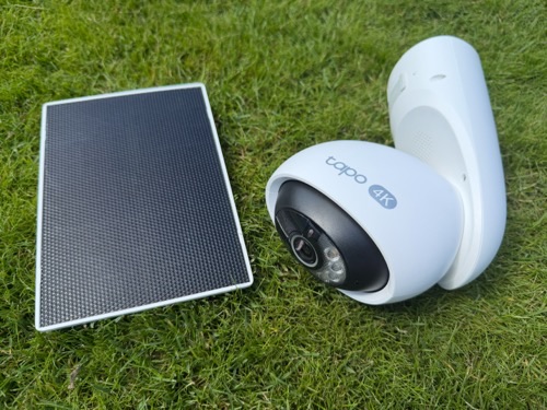 Tapo C660 Kamera neben dem abgenommenen Solarpanel auf einer Rasenfläche