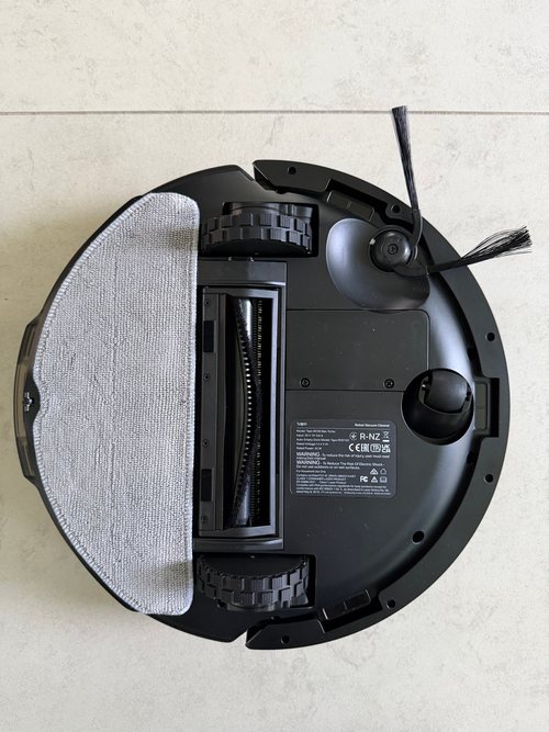 Unterseite des Tapo RV30 Max Turbo mit Wischaufsatz, Hauptbürste, zwei Antriebsrädern, Lenkrad, Seitenbürste und Typenschild